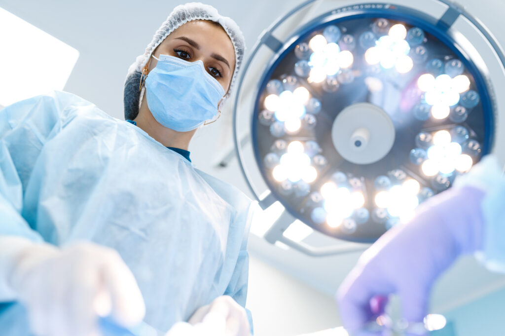 Surgeon in an operating room with lights in the background