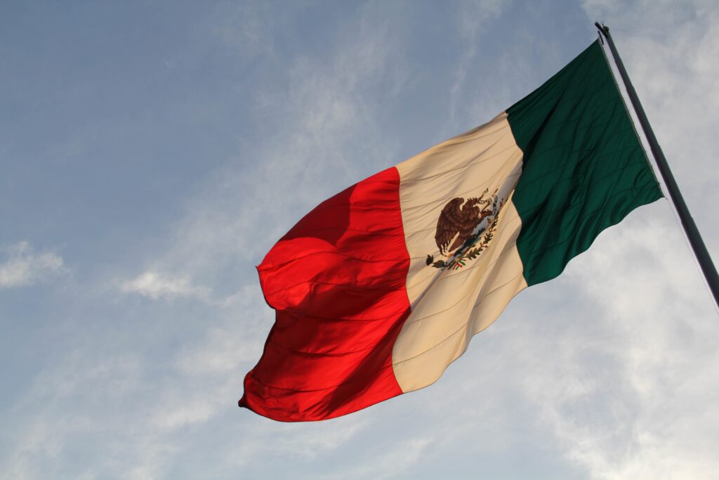 Mexican flag flying in the sky.
