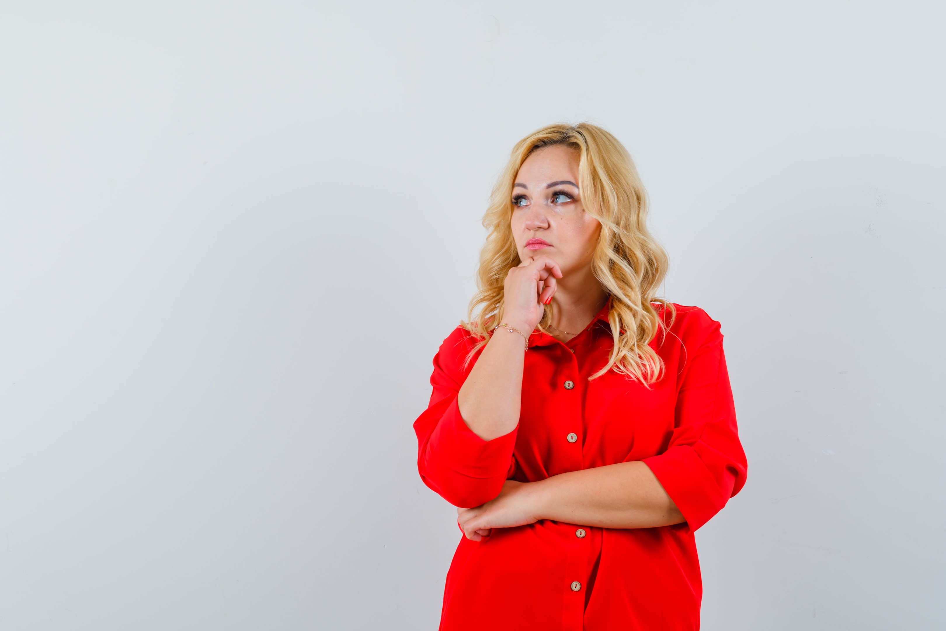 Women wearing a red blouse thinking about something.